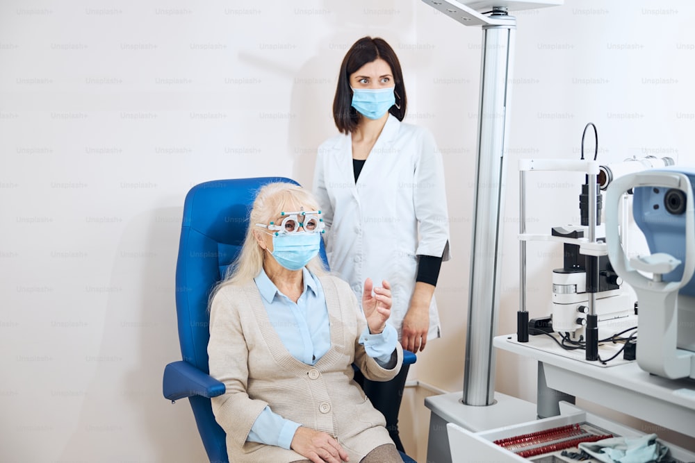 Qualified eye doctor checking the clarity of the senior lady vision during the eye examination