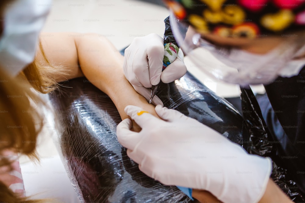 Latin Frau Tattoo Master zeigt einen Prozess der Kreation Tattoo in Mexiko-Stadt