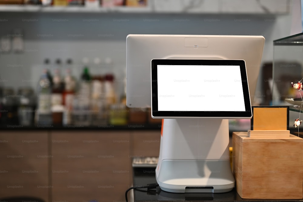 Una cajera de pantalla táctil con pantalla en blanco en una cafetería moderna.