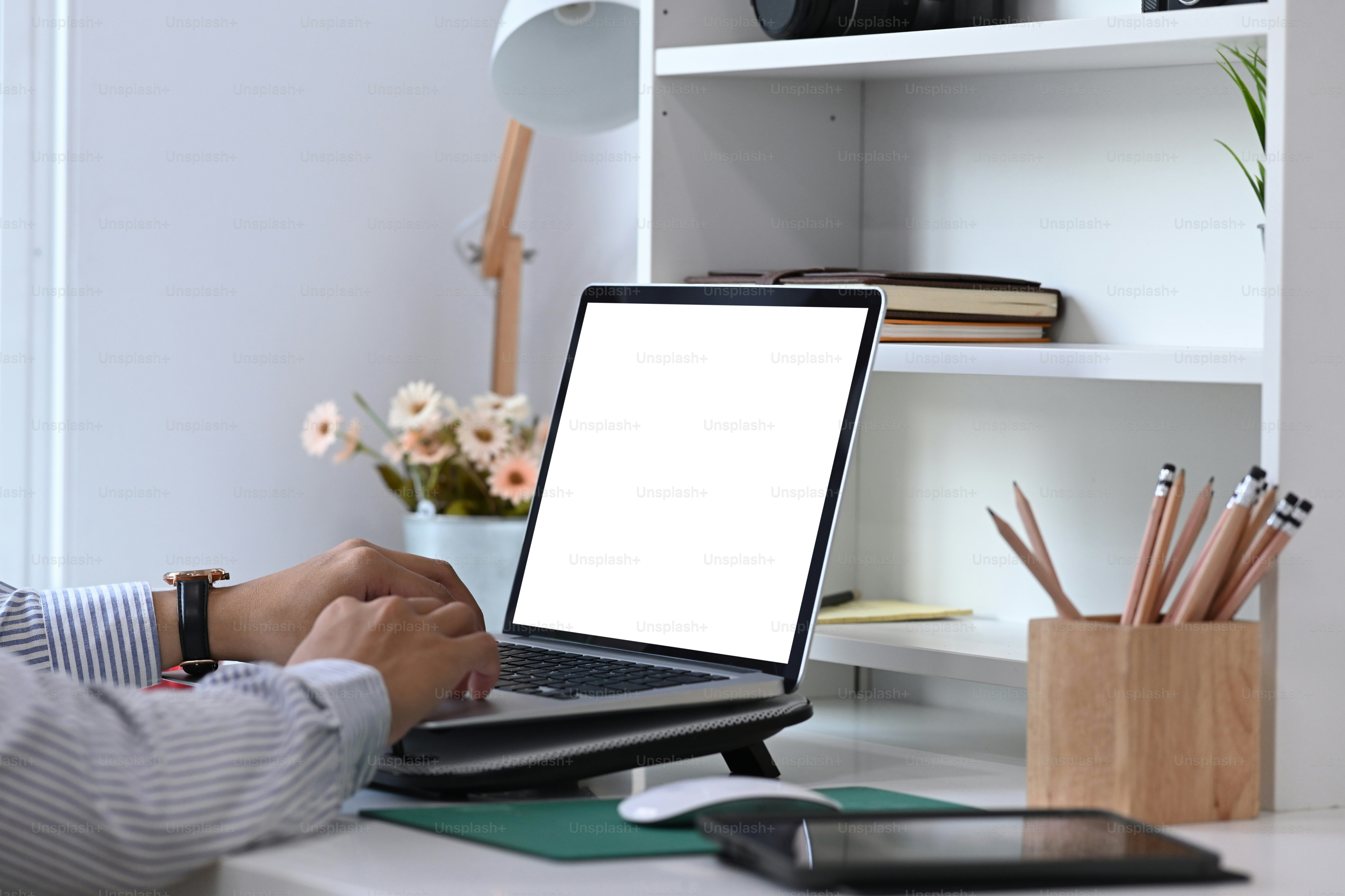 Vue rapprochée, je tape sur le clavier de la maquette d’ordinateur portable avec écran blanc vide