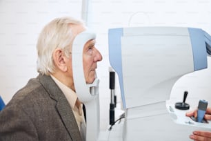 Side view of an elderly patient undergoing the air puff test performed by a qualified optometrist
