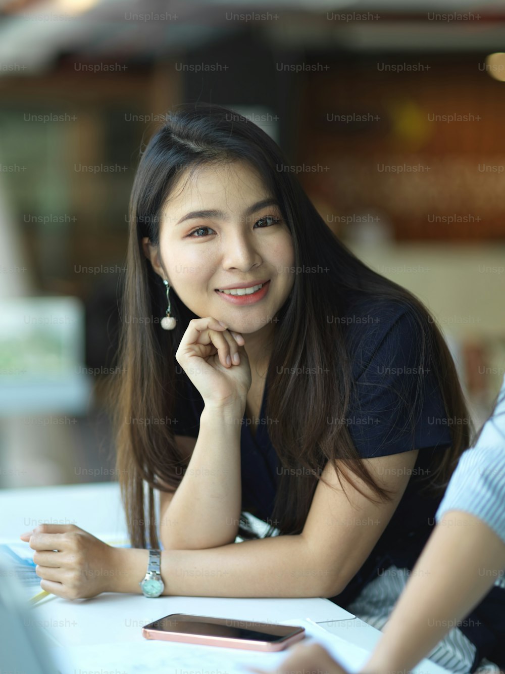 Portrait of businesswoman smiling to camera while working with her coworker in meeting room