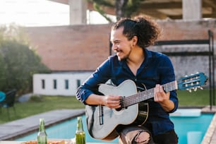 mexican man playing guitar outside home in Mexico city