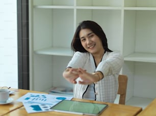 Portrait of businesswoman relaxing, stretching her arms while working in office room