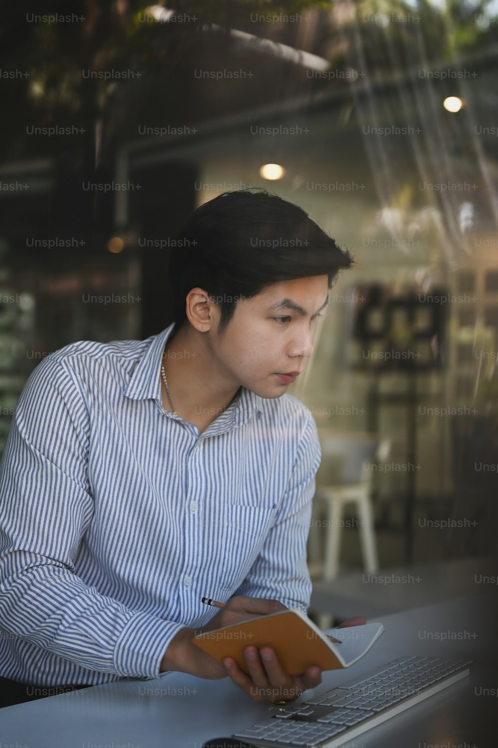Portrait of young man employee working with laptop computer in modern office.