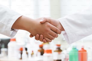 Handshake of doctors or scientists against blurred background