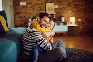 Affectionate little girl and her father embracing while relaxing in the living room.