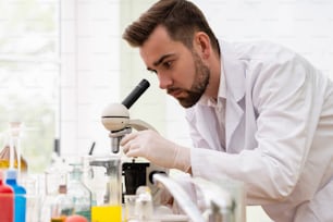 Scientist is using microscope in a laboratory during research work