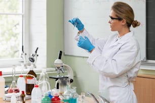 Scienziato che ispeziona la sostanza all'interno della provetta in un laboratorio durante il lavoro di ricerca.