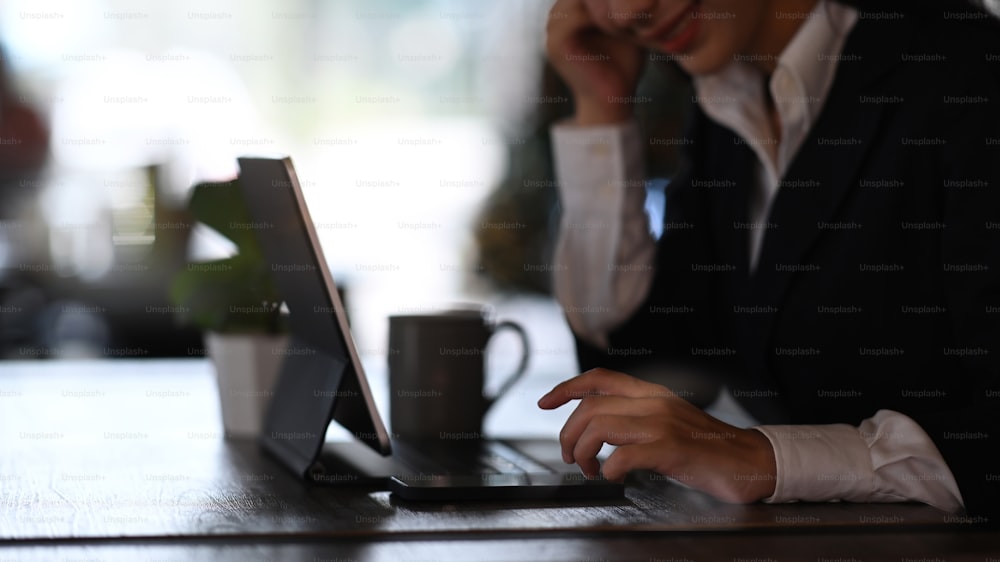 Cropped shot of businesswoman working on tablet computer at office.