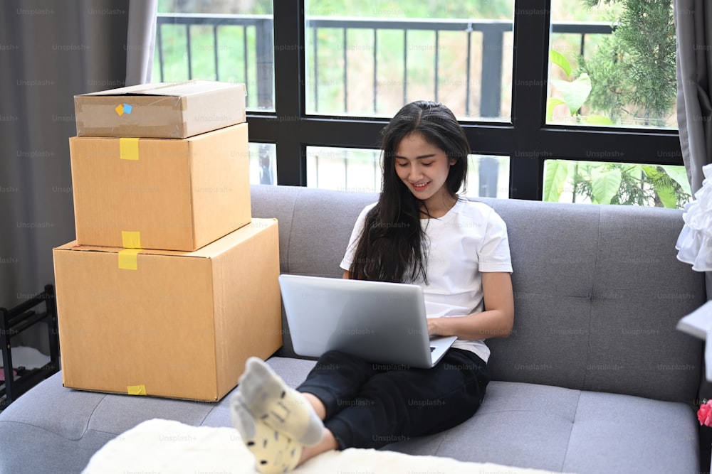 Comece a empreender de pequenas empresas ou mulher freelancer sentada no sofá em casa e trabalhando com laptop.
