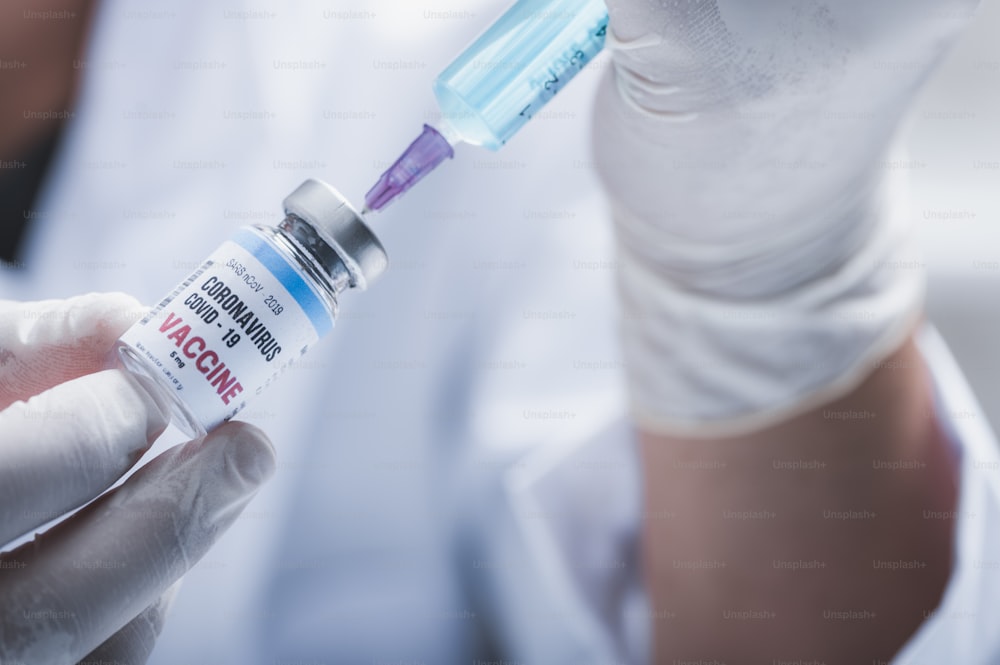 lucha contra el COVID-19, investigación de la vacuna contra el coronavirus en el laboratorio, científicos profesionales sostiene la vacuna de jeringa y botella para la inyección del tratamiento de la cura del virus, medicina clínica durante la pandemia