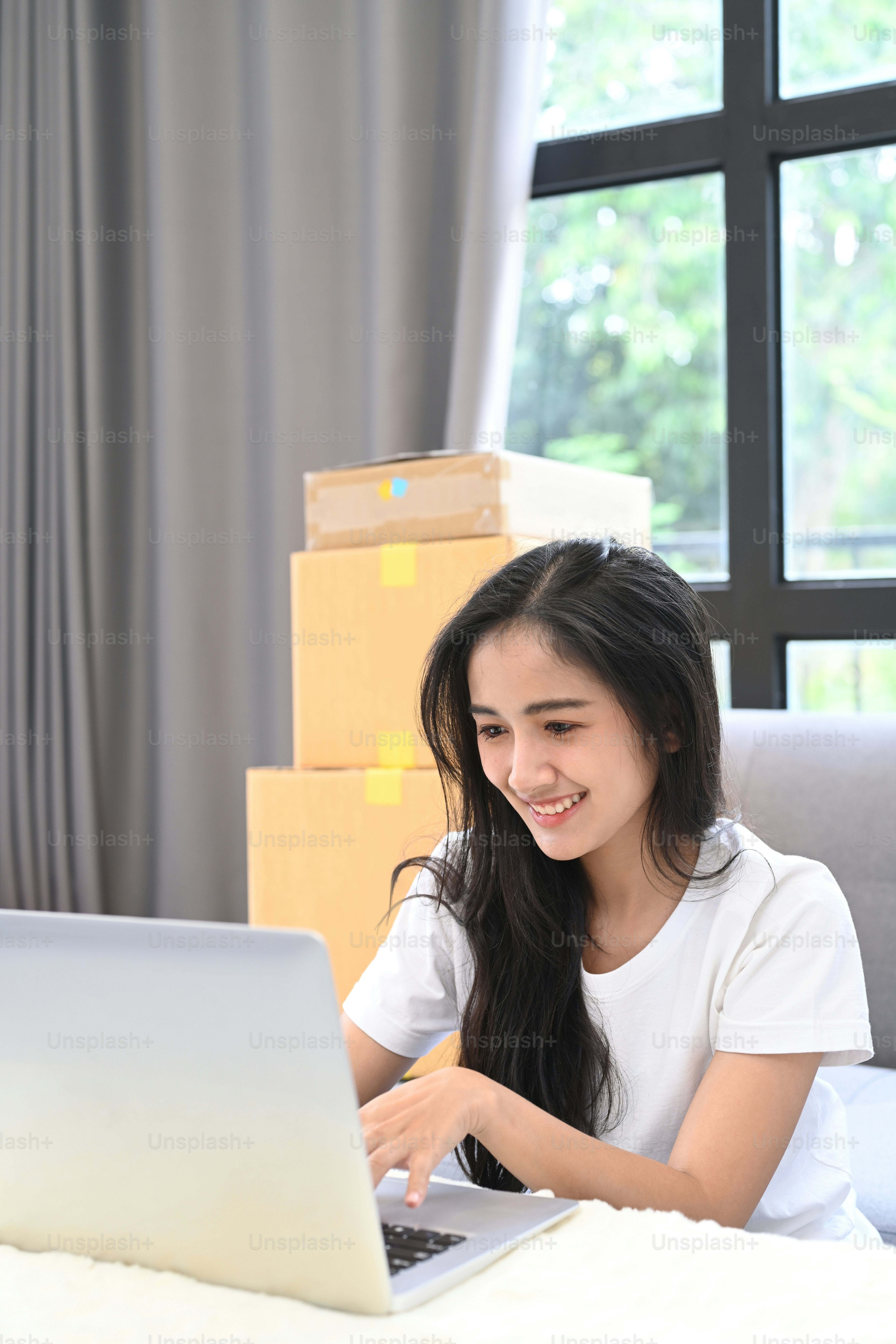 Start up small business owner working on laptop computer checking order on internet at her startup home office. Online Selling or Online Shopping concept.