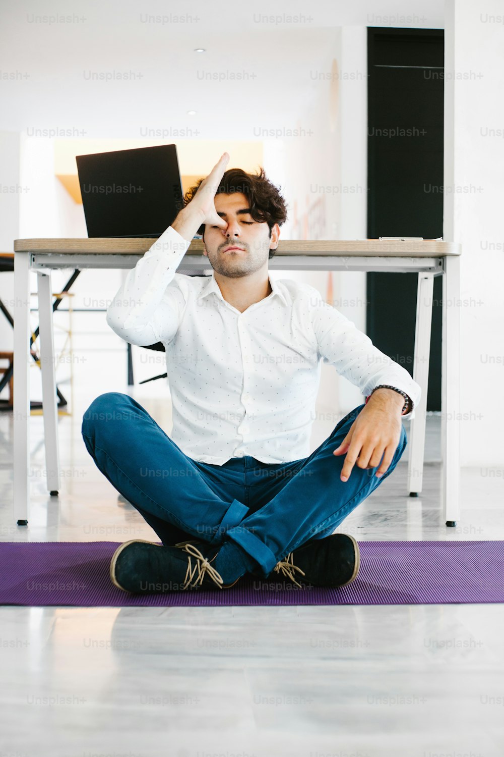 ラテンアメリカのオフィスで瞑想し、ヨガをする若いメキシコ人男性