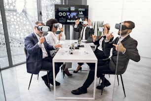 Team building seminar, technology concept. Multiracial business people, using VR glasses, making team training, gesturing, and enjoying work together.