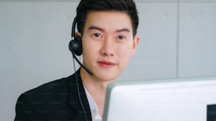 Business people wearing headset working in office to support remote customer or colleague. Call center, telemarketing, customer support agent provide service on telephone video conference call.