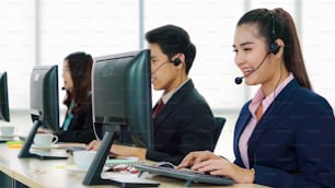 Business people wearing headset working in office to support remote customer or colleague. Call center, telemarketing, customer support agent provide service on telephone video conference call.