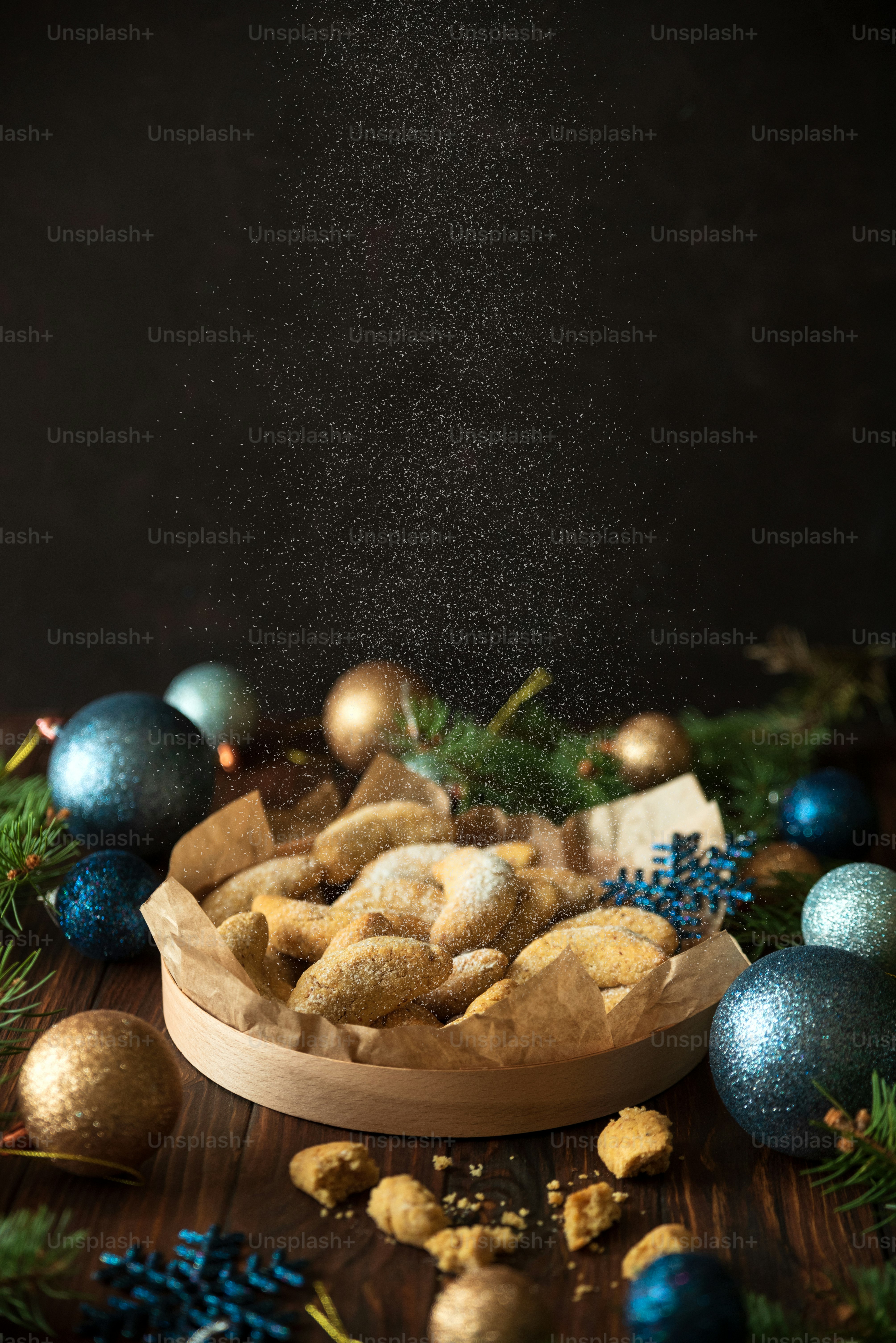 Homemade Christmas nuts cookies vanilla crescent with sugar powder in Christmas decorations. New Year and Christmas celebration concept. Copy space. Soft focus. Flying sugar powder