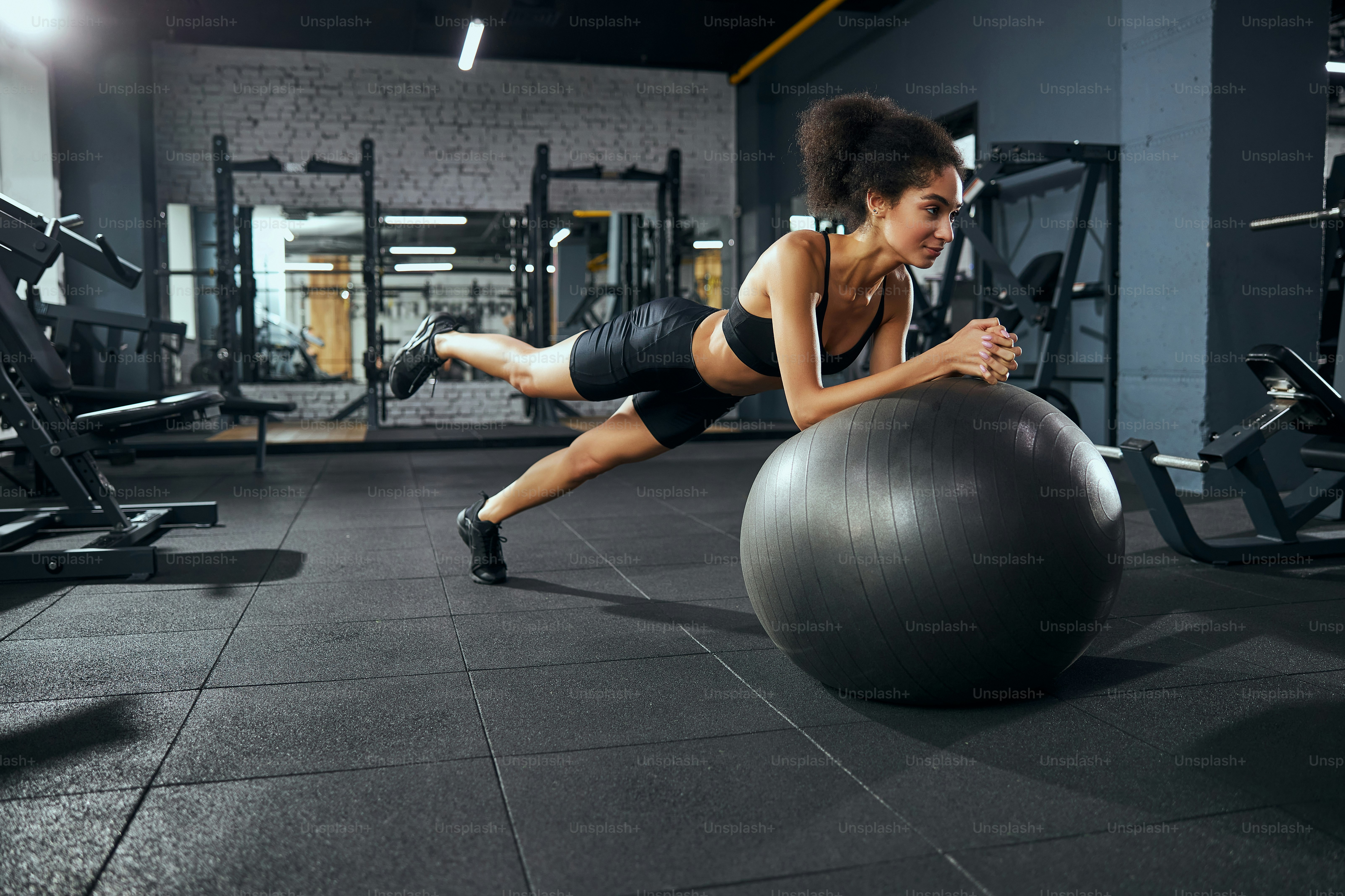 Cute female person expressing positivity while training alone at the gym
