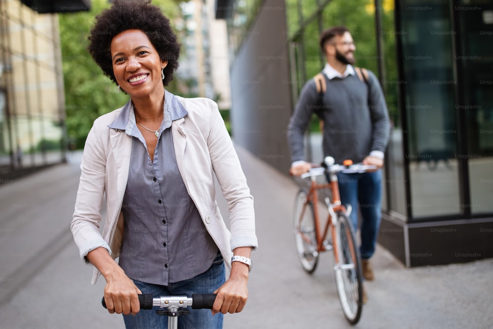 Pareja interracial feliz usando scooter eléctrico, bicicleta en la ciudad. Concepto de energía ecológica verde con cero emisiones