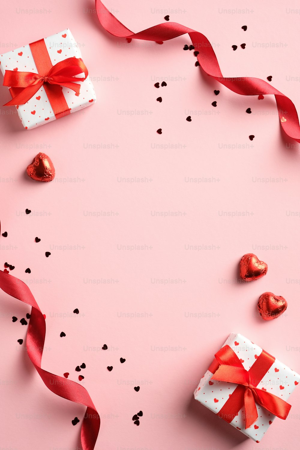 Valentinstag flache Lay Komposition mit rotem Band, Geschenke, Konfetti auf rosa Hintergrund. Geeignet für vertikales Banner, Flyer, Broschüre, Geschichten in sozialen Medien