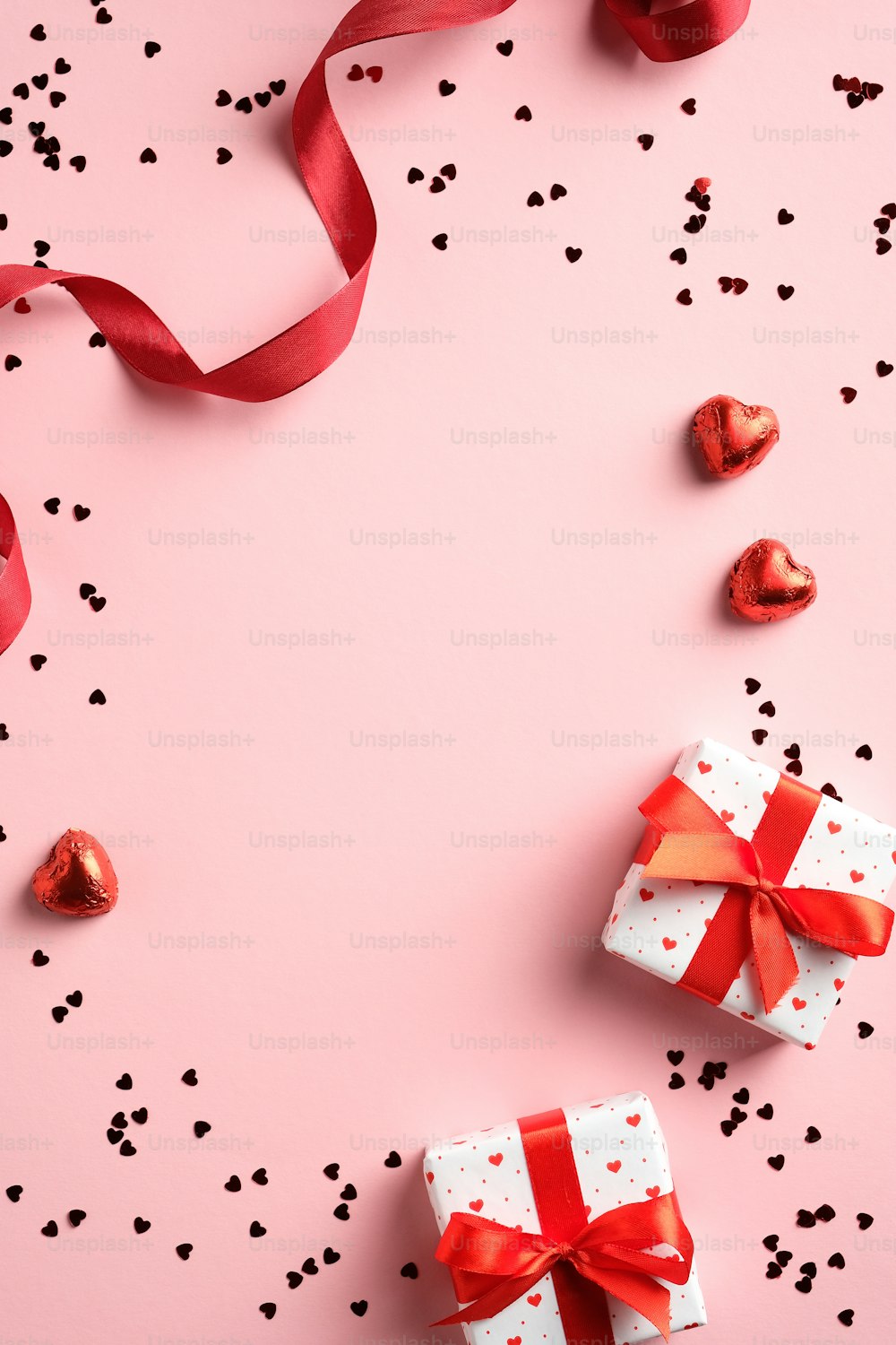 Happy Valentine's Day Konzept. Vertikales Banner mit Geschenkboxen, rotes Band, Konfetti auf rosa Tisch. Draufsicht, flach gelegt. Valentinstag Geschenkgutschein Design, Grußkarte, Story Design auf Social Media