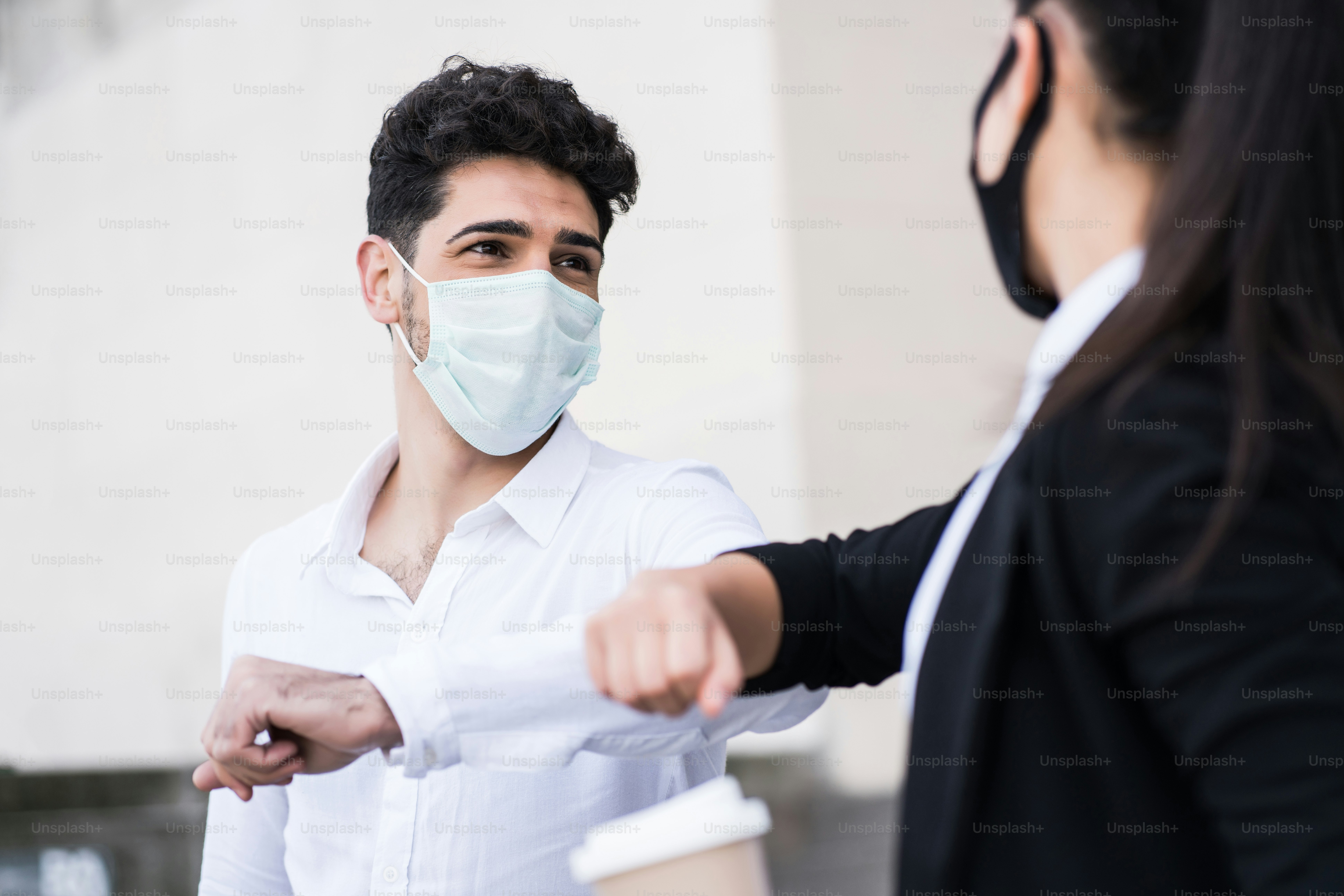 Portrait of two business people bumping elbows for greeting each other outdoors. Business concept. New normal lifestyle concept.