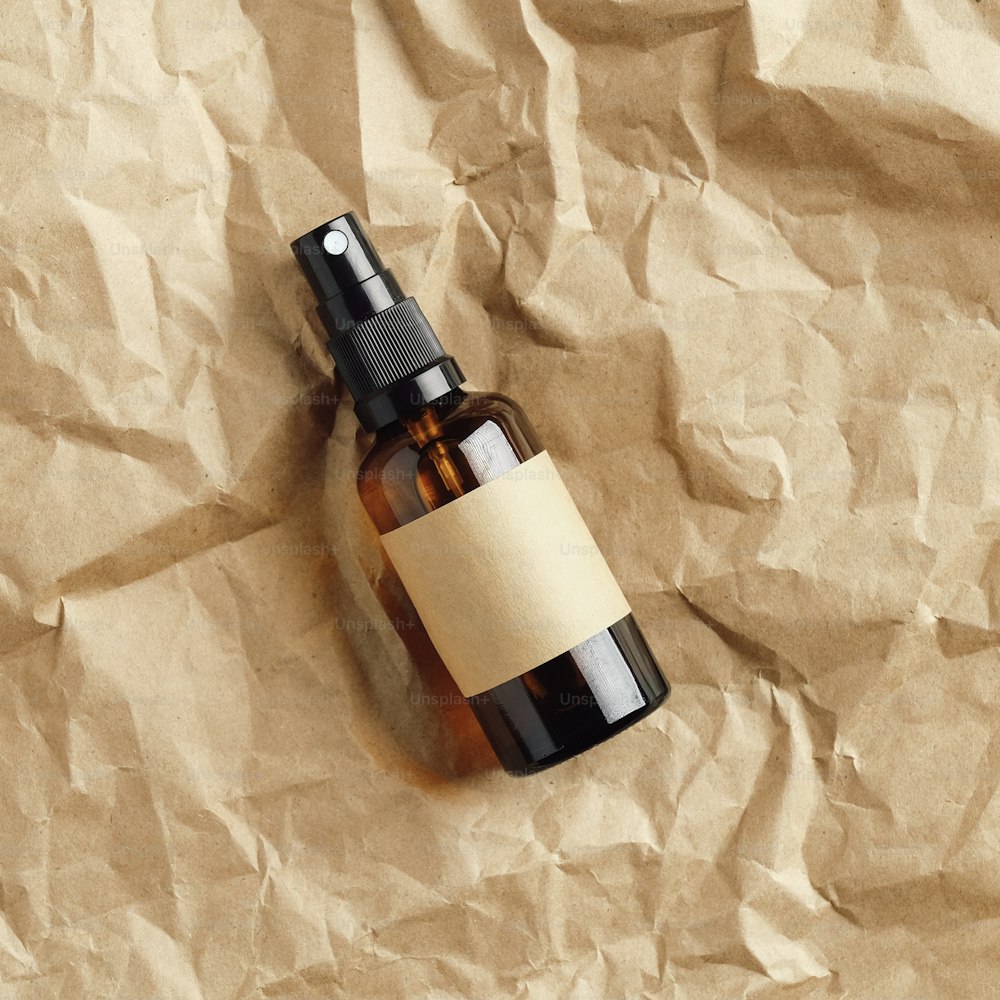 Maqueta de botella de cosméticos en aerosol de vidrio ámbar en papel kraft. Diseño de packaging para cosmética natural, producto de belleza ecológico.