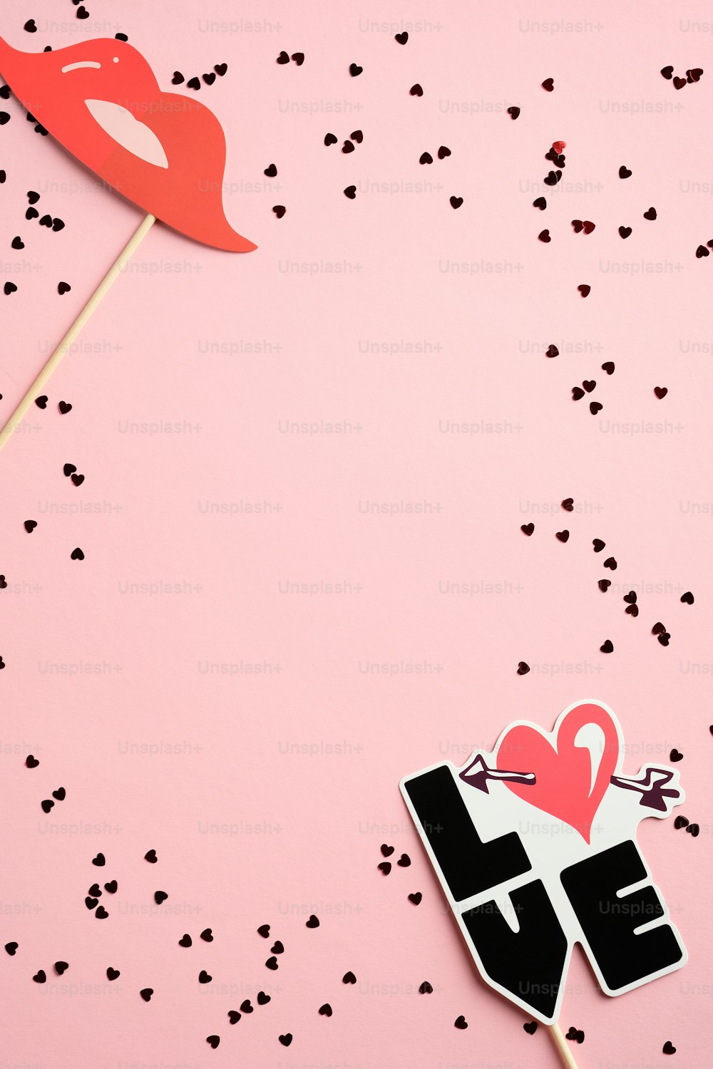 ピンクのテーブルにモダンな装飾と紙吹雪を配したバレンタインデーの縦型バナーテンプレート。バレンタインデーのギフト券のモックアップ、グリーティングカードのデザイン。