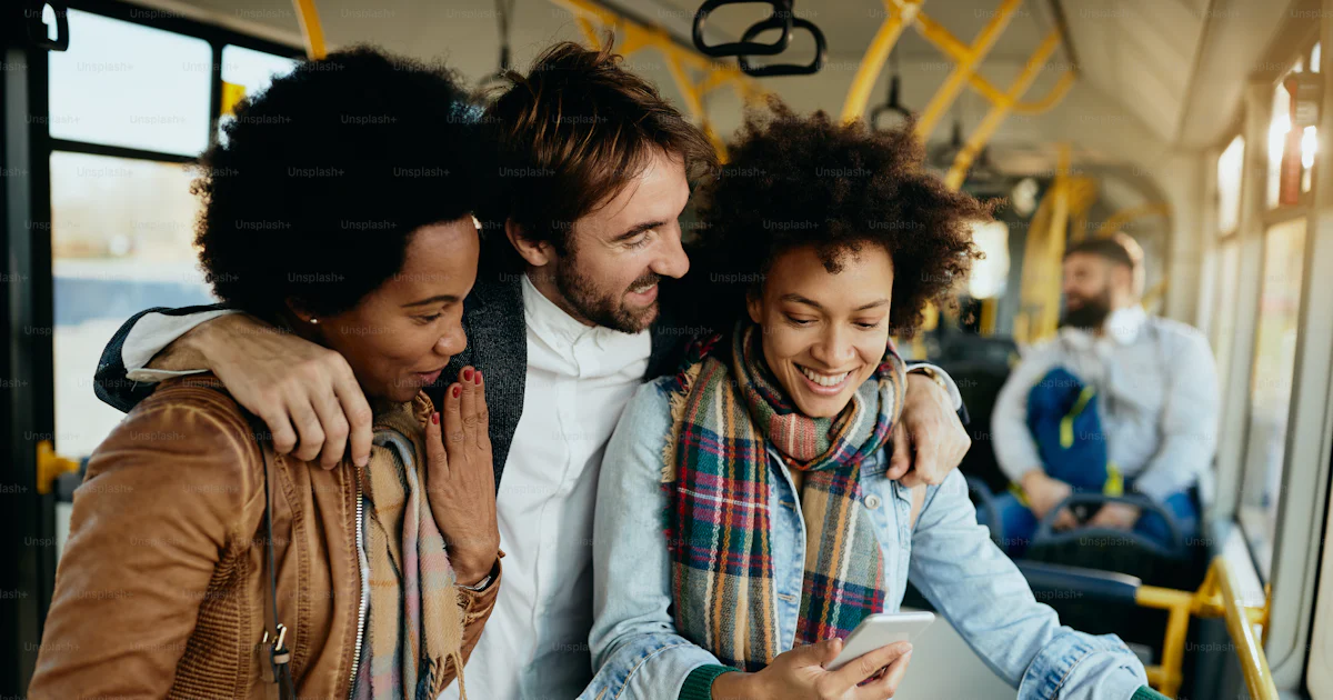 Group of happy friends using mobile phone and having fun while ...