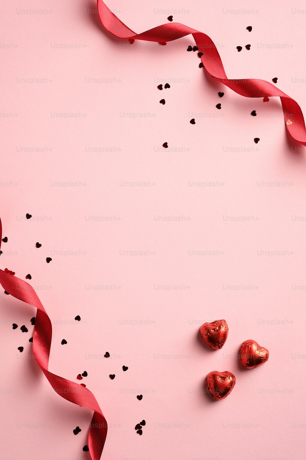 Biglietto di buon San Valentino con nastro rosso, coriandoli, dolci a forma di cuore su sfondo rosa. Banner verticale, brochure, design di poster.