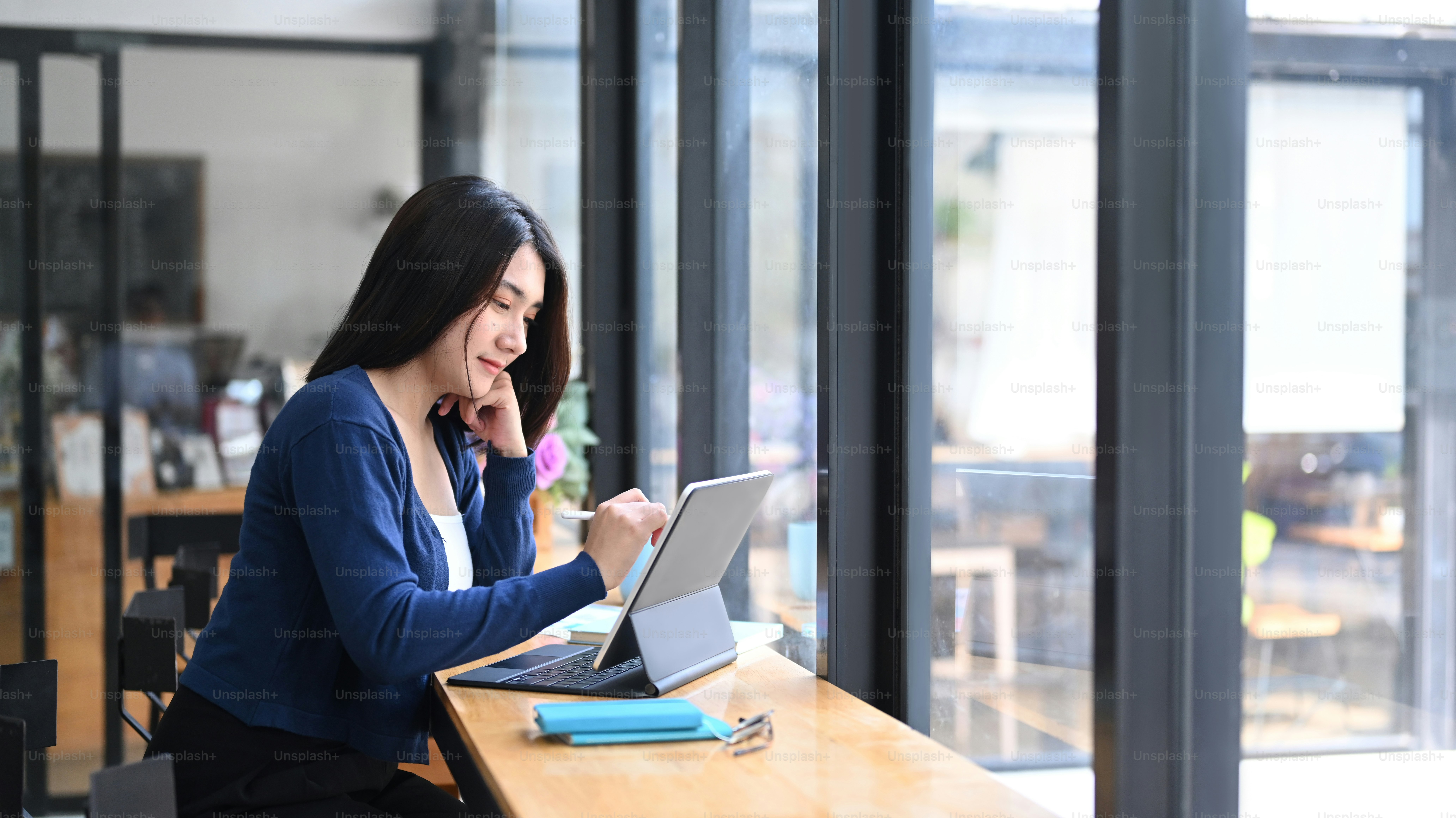 Jeune pigiste joyeuse travaillant avec une tablette à un poste de travail confortable.