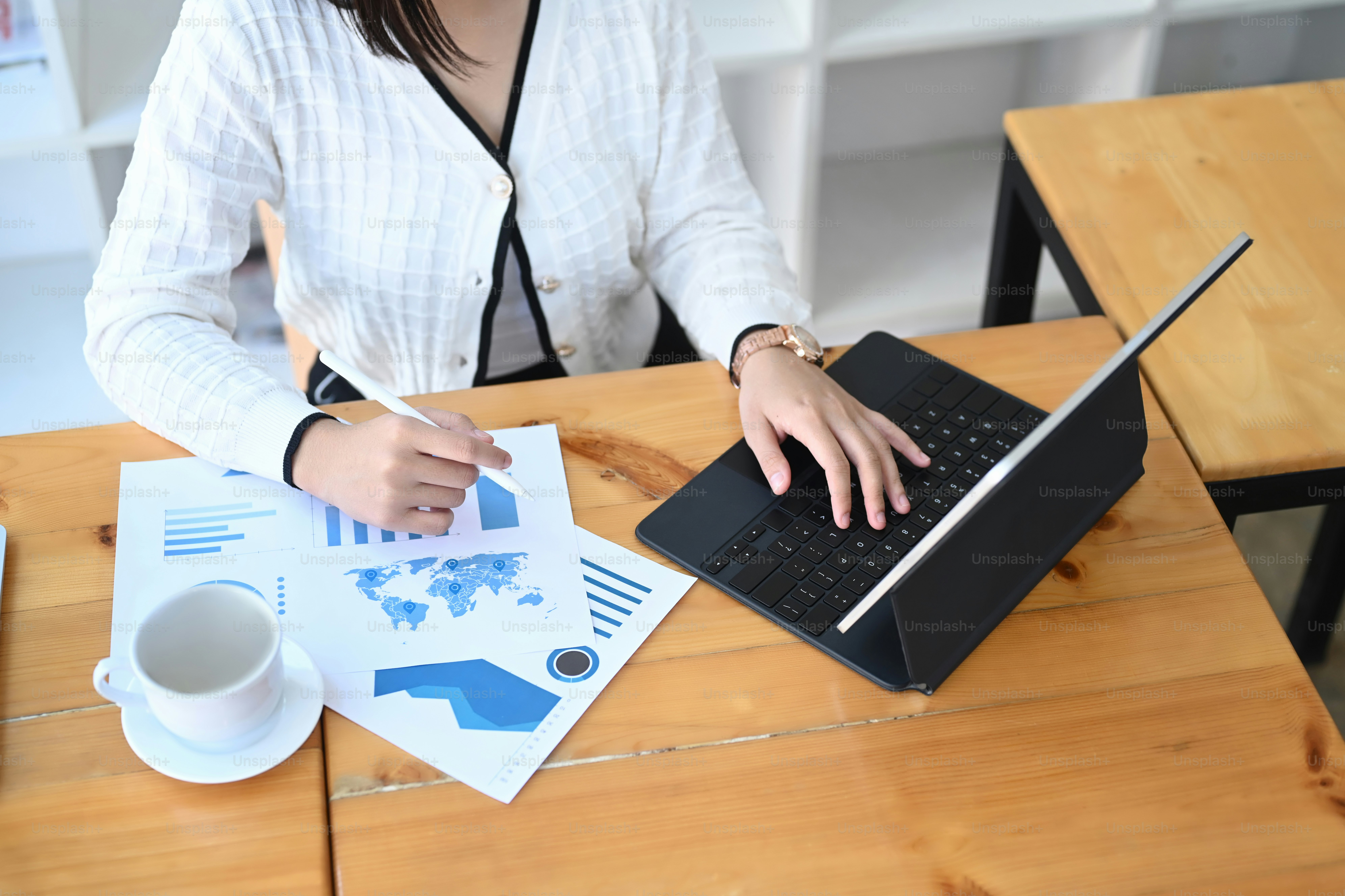 Businesswoman working on tablet computer and analyzing marketing strategy at office.