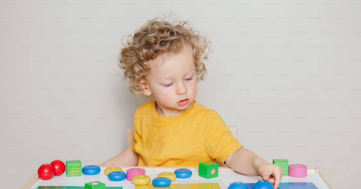 Toddler playing with learning toys at home or kindergarten. Baby ...