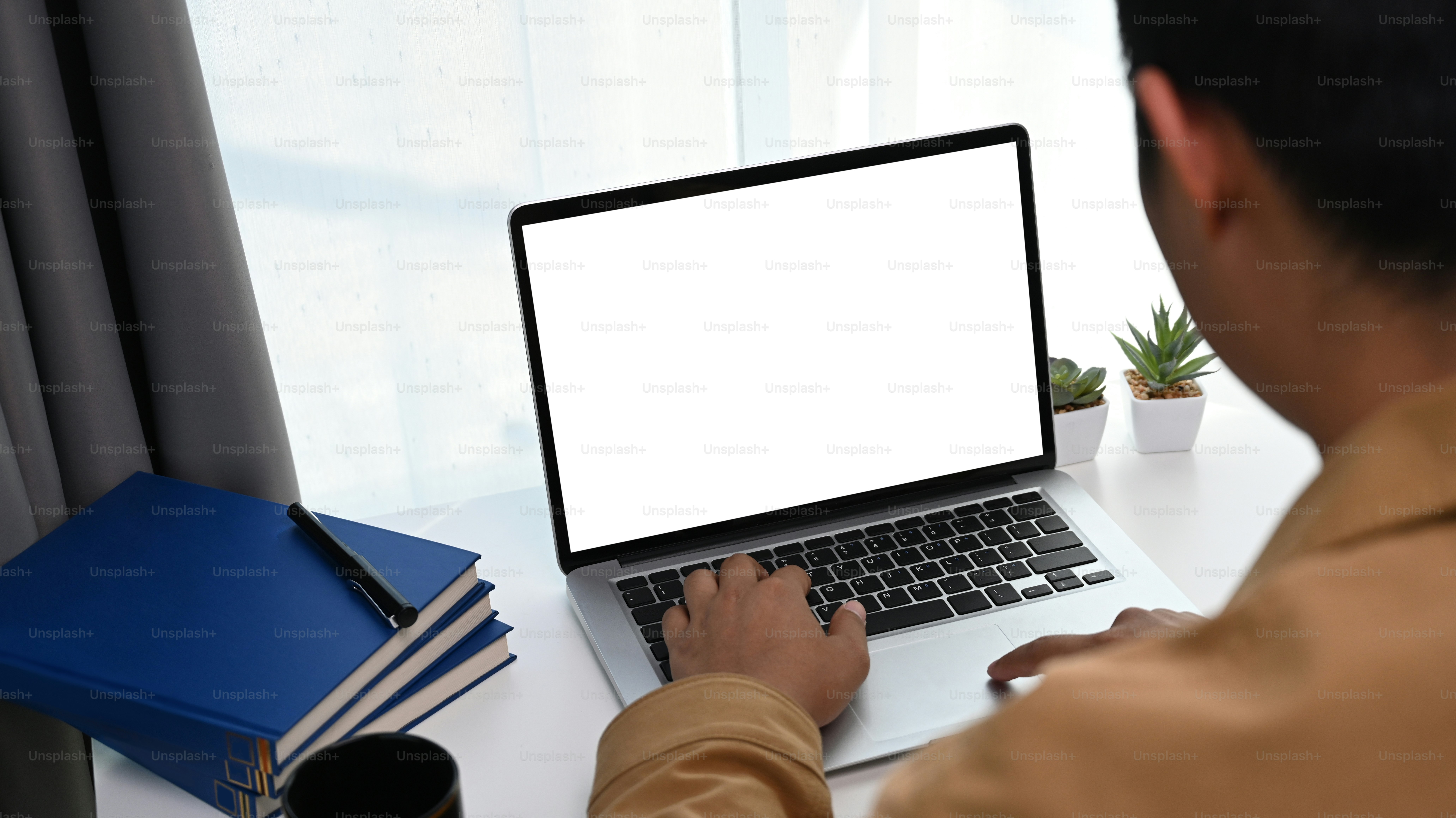 Rear view of young man using modern computer during working online at ...
