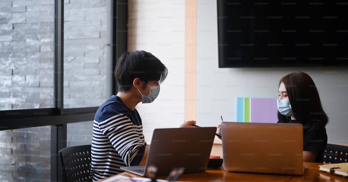 Group of creative startup people with protective mask discussing ...