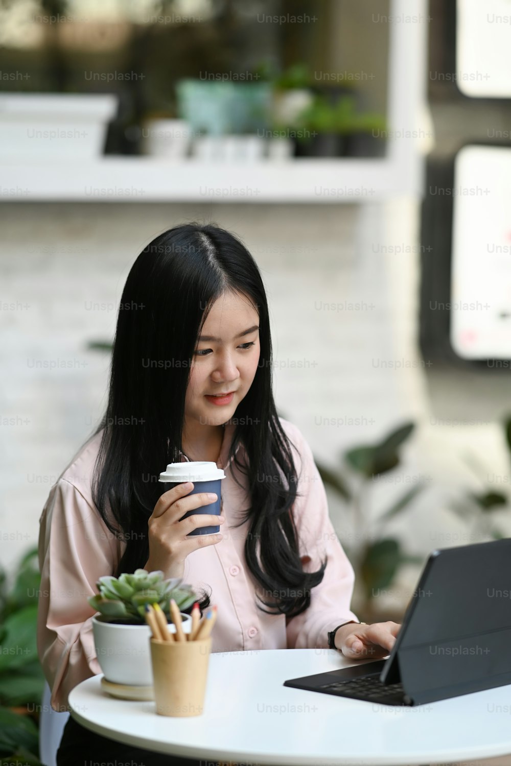 Young attractive woman sitting in a cafe in the morning before her work.