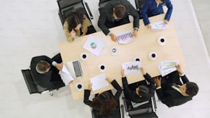 Business people group meeting shot from top view in office . Profession businesswomen, businessmen and office workers working in team conference with project planning document on meeting table .