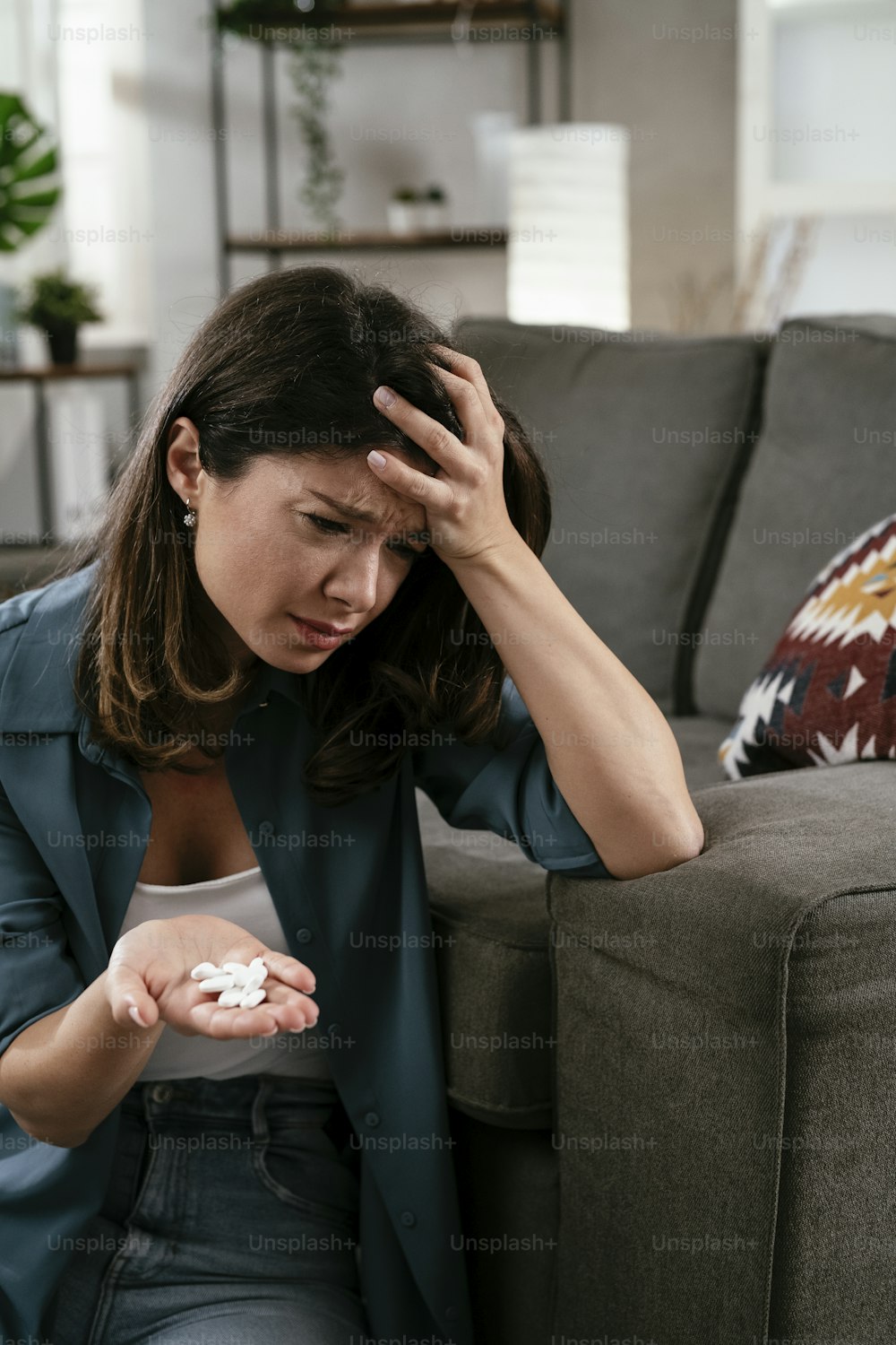 Traurige unglückliche depressive Frau hält eine Pille in der Hand. Verzweifelte junge Frau mit einer Handvoll Pillen.
