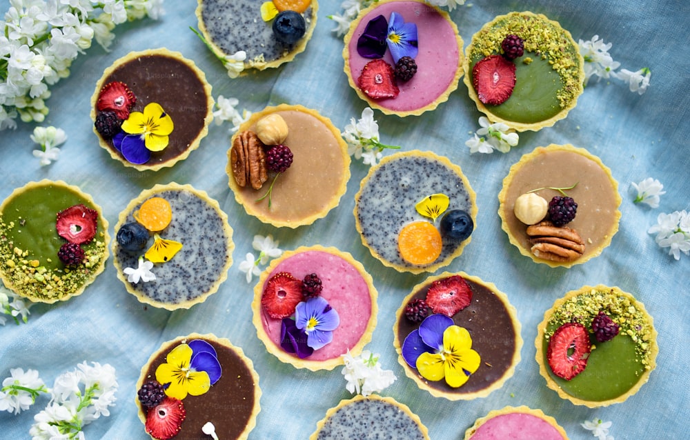 Uma seleção de sobremesas de bolo coloridas e deliciosas em caixa sobre a mesa, vista superior.