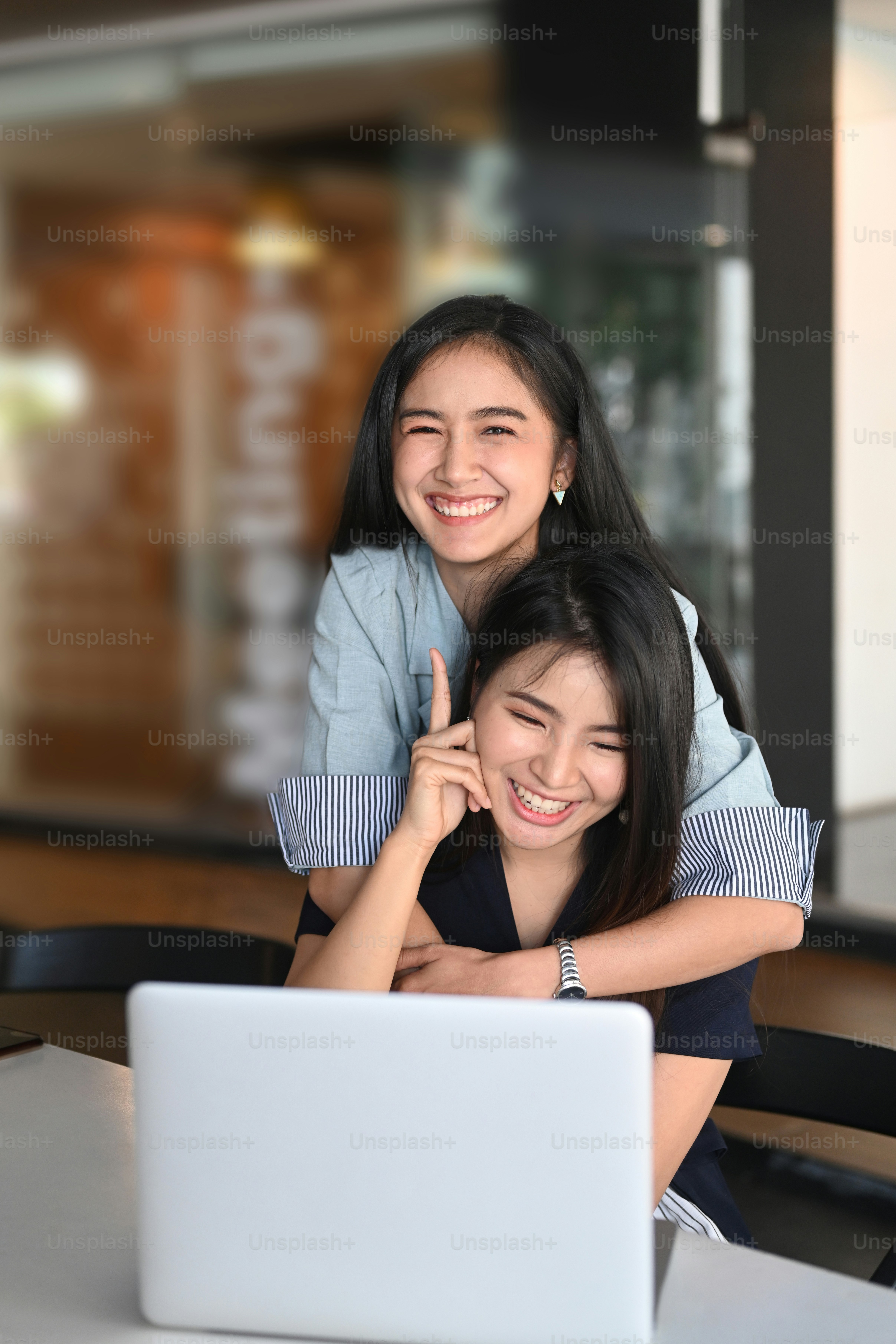 Portrait de rire émotif heureux positif deux femmes collègues au bureau.