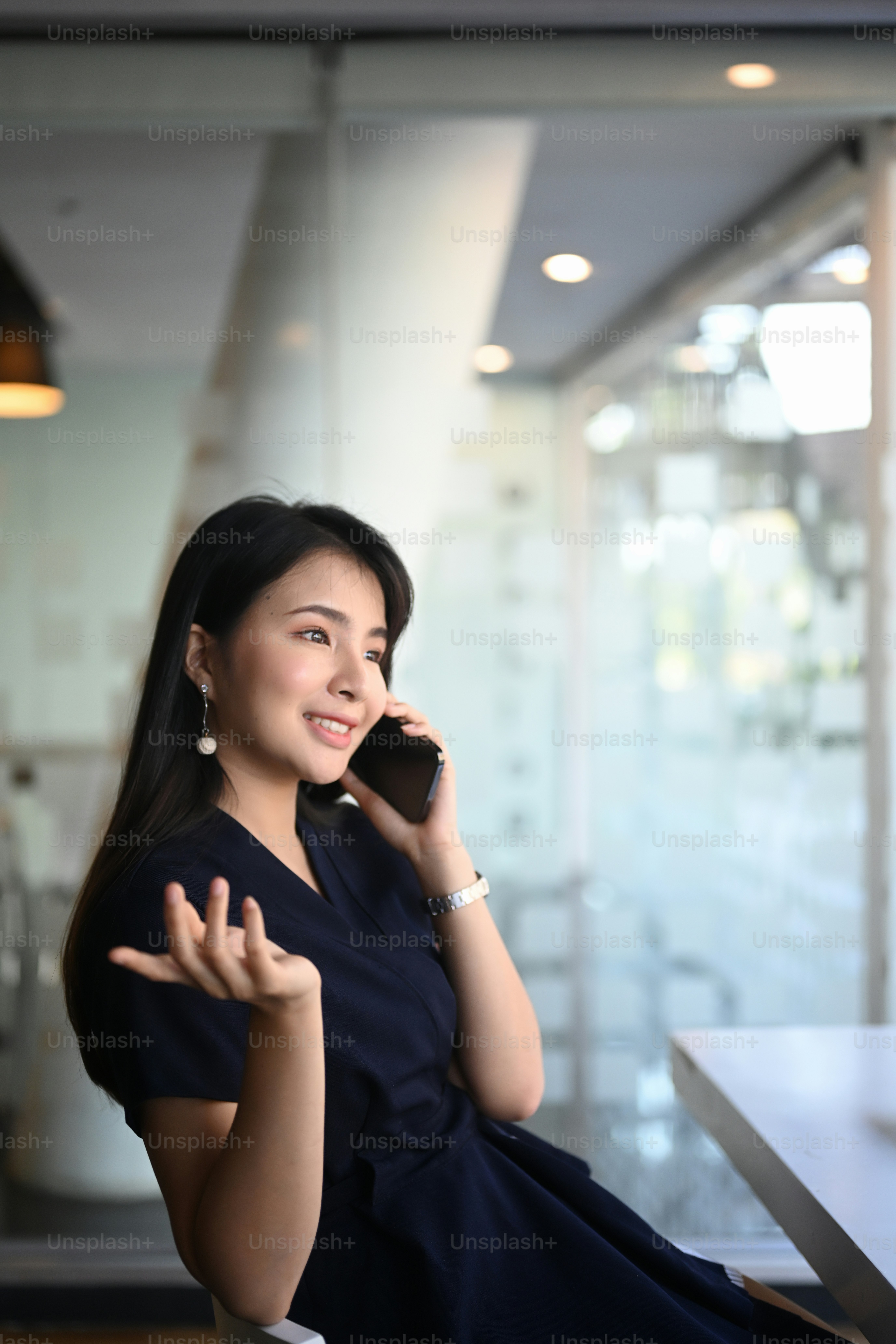 Portrait of businesswoman talking on mobile phone about business strategy at office.