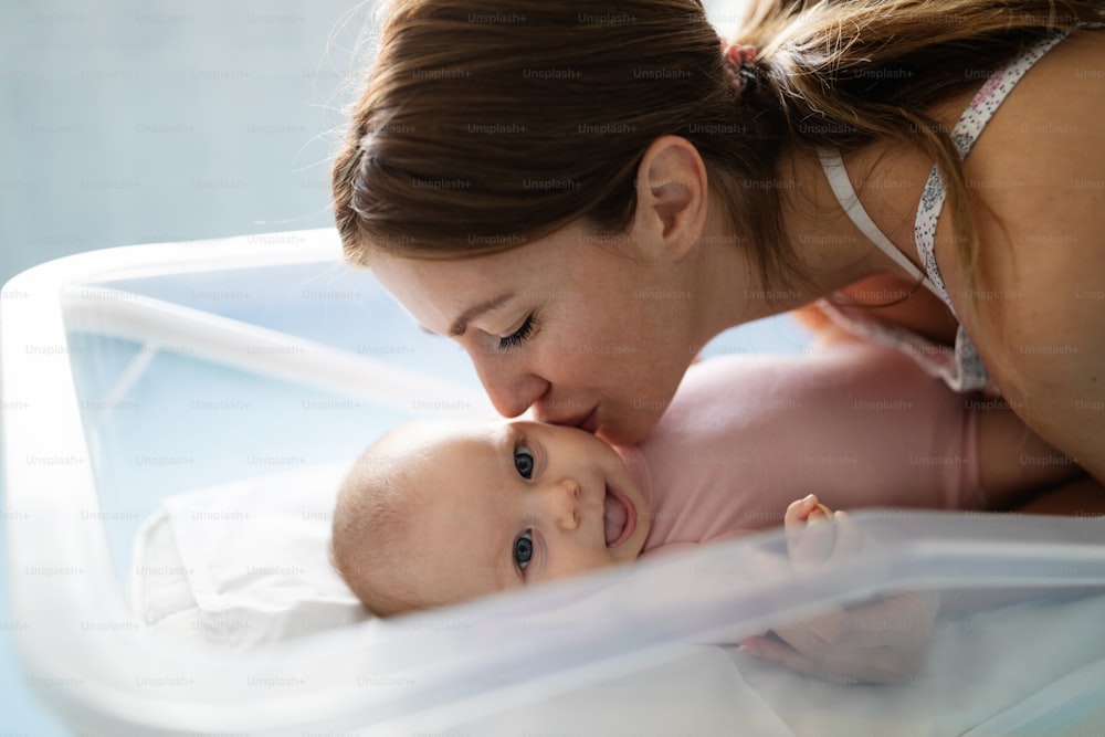 Happy smiling mother with newborn baby in hospital