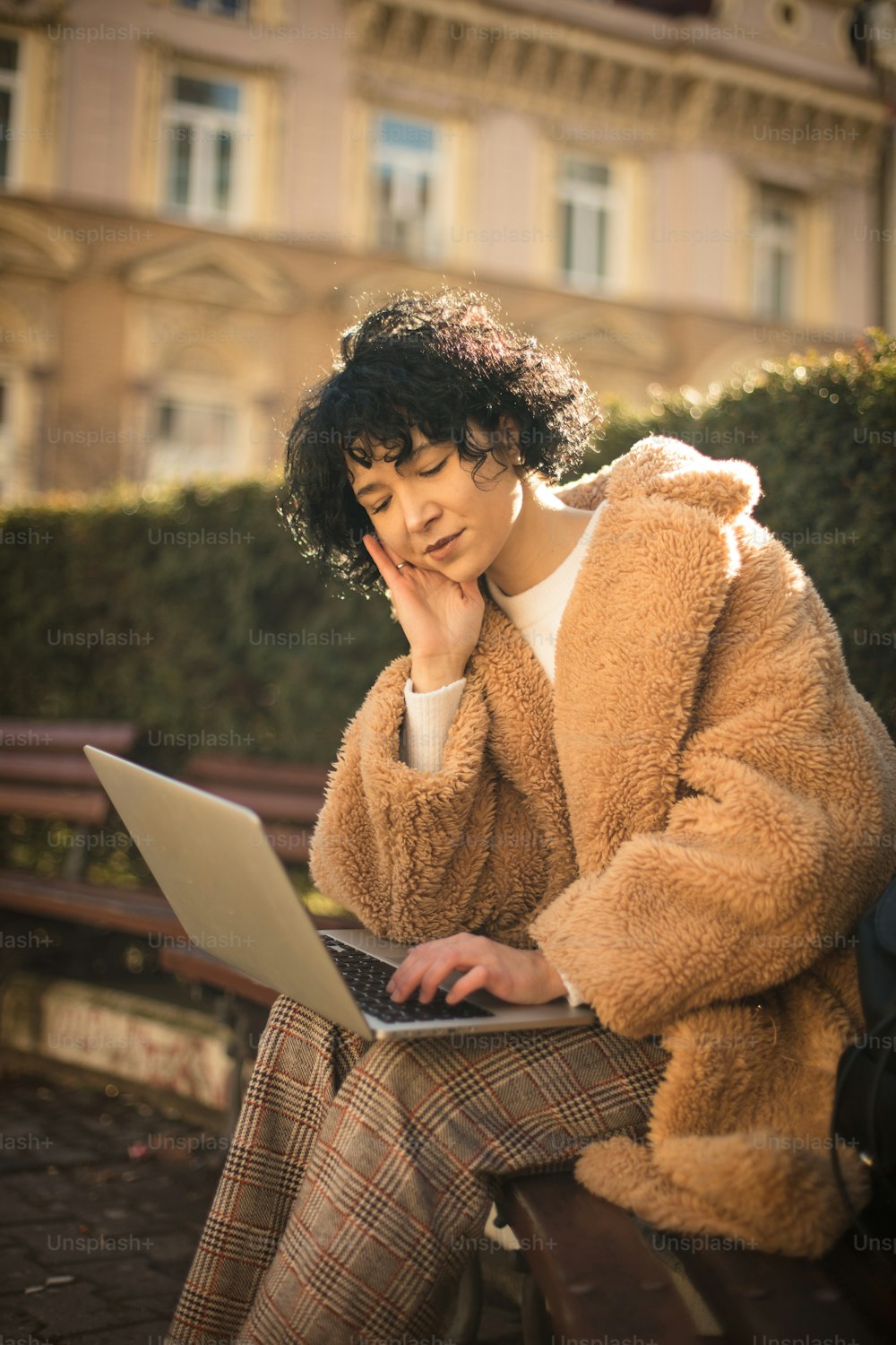 Mujer de negocios usando computadora portátil en el parque de la ciudad.