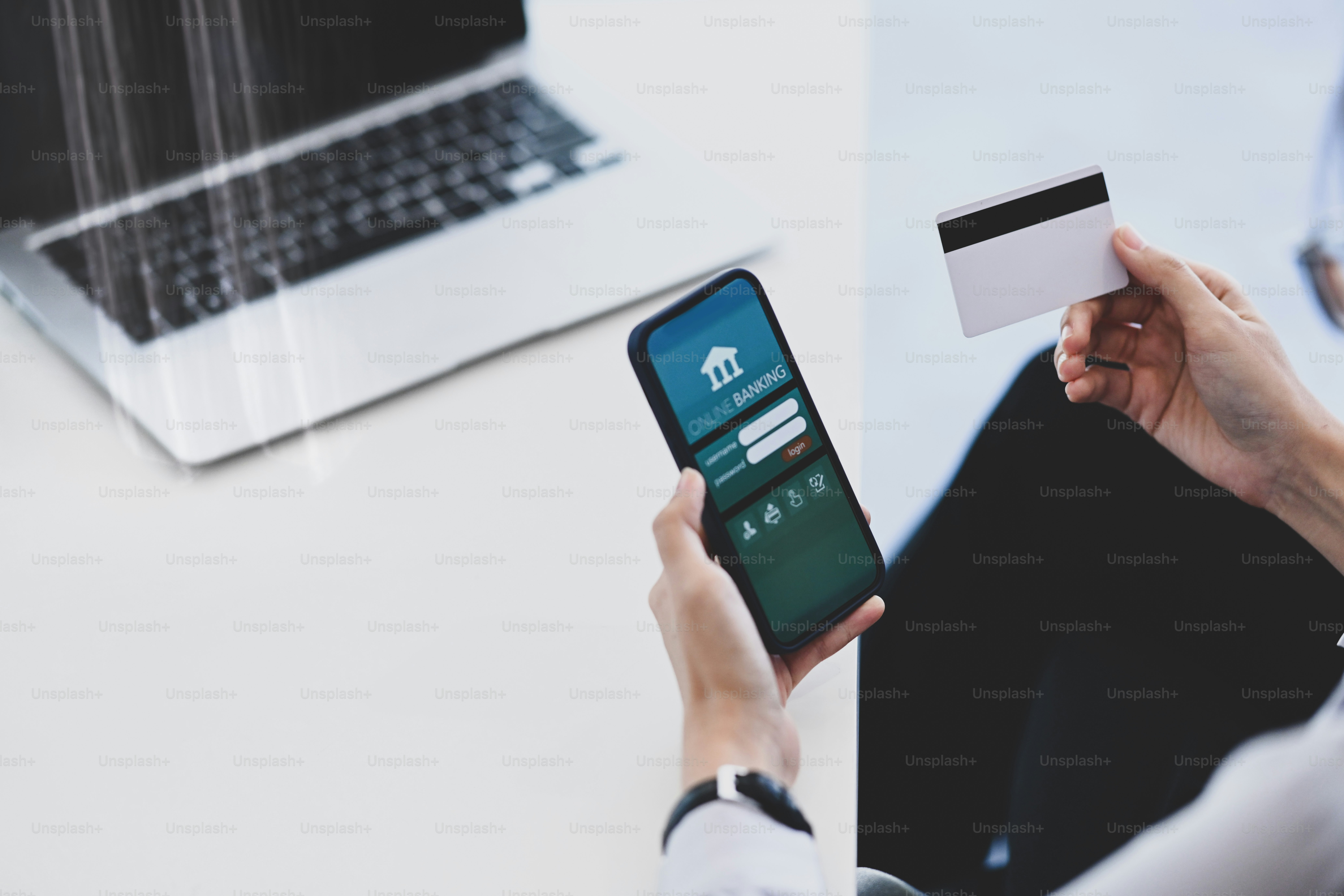 Cropped shot of young woman using smart phone and holding credit card making payment online or online banking.