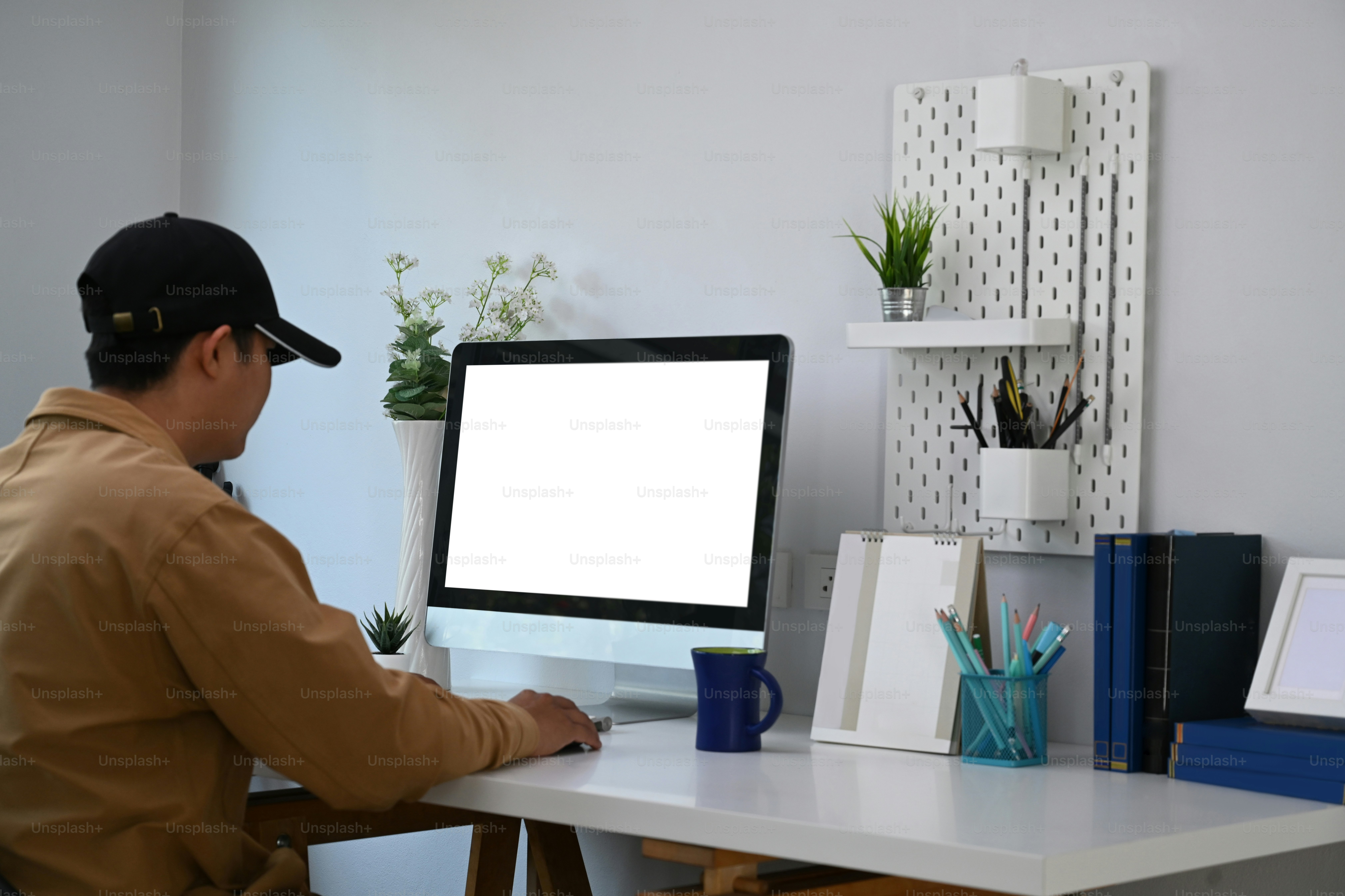 Young man sitting in comfortable workplace and working from home with computer.