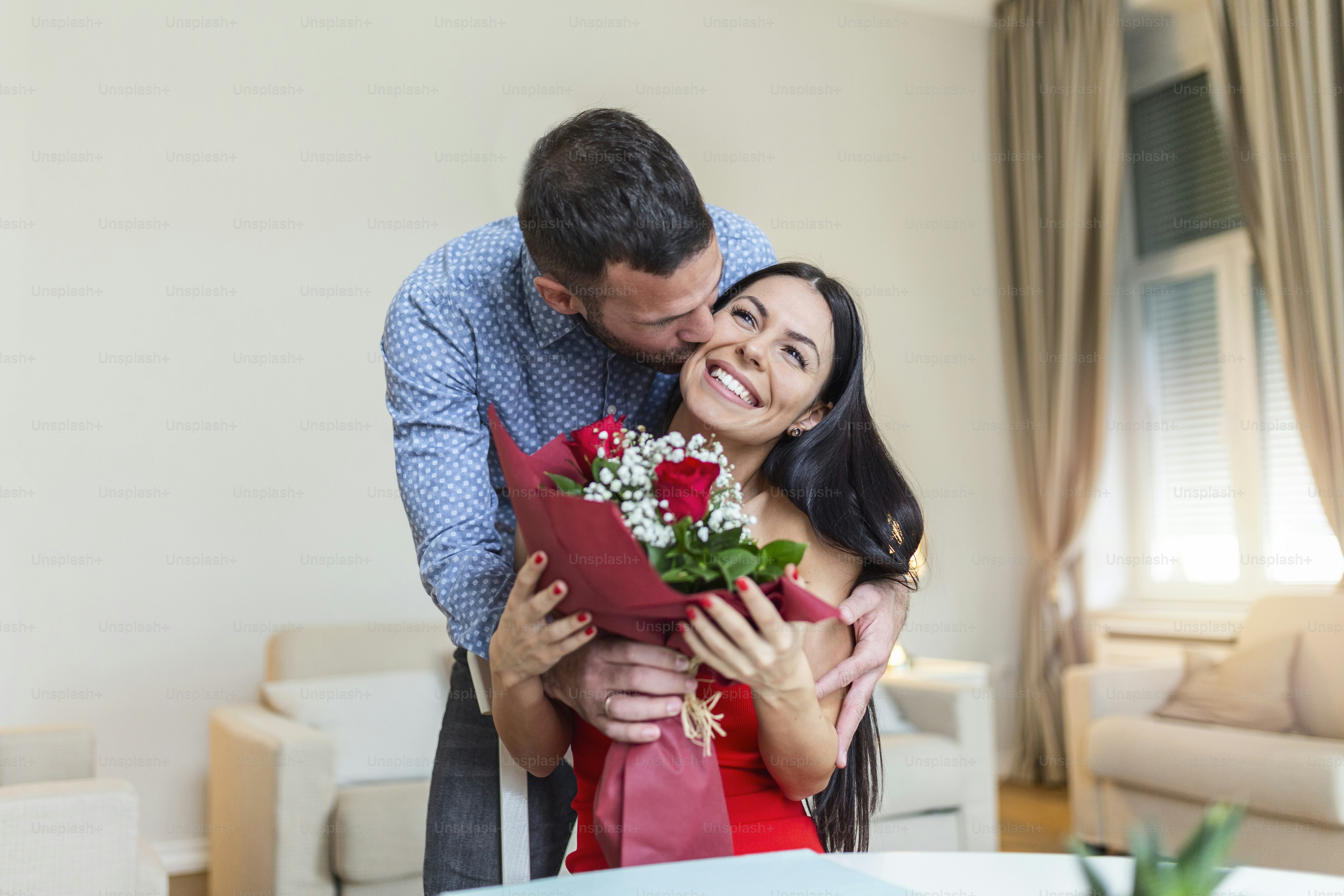 Excited young woman receiving unexpected Bouquet of red roses from ...