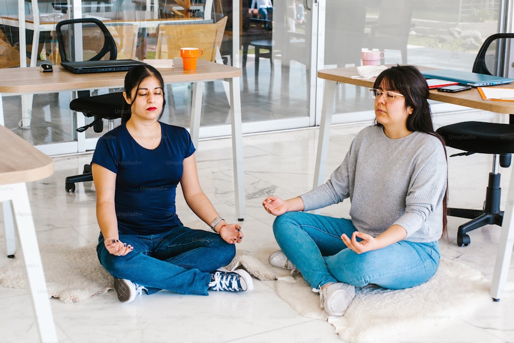 latin business people meditating and doing yoga in office in Mexico city