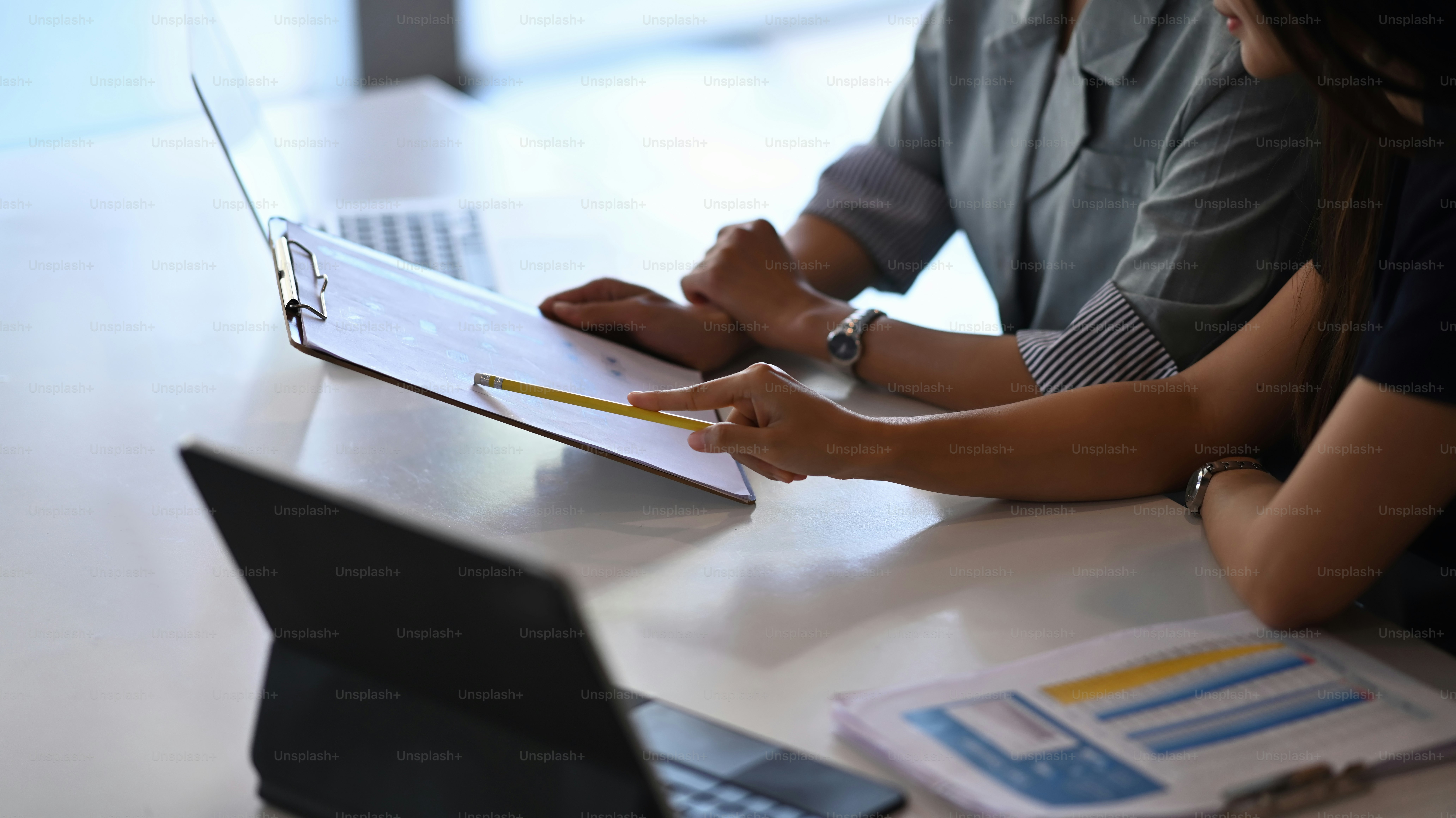 Cropped shot of businesswomen sitting at office desk talking of business plan and strategy.