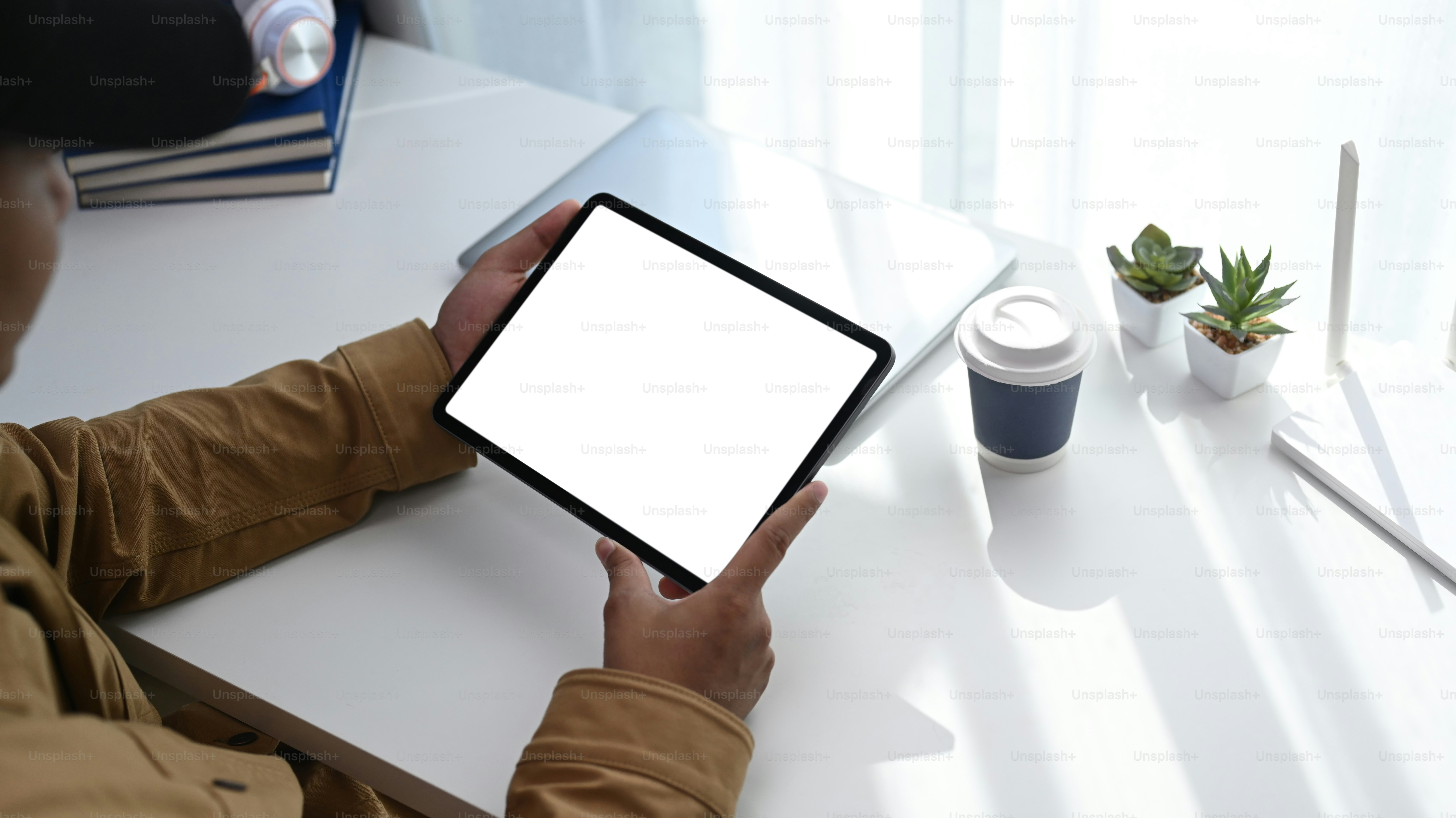 Plan recadré d’un jeune homme utilisant une tablette numérique pour se connecter à Internet ou à une connexion sans fil à la maison.